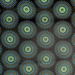 Original Shweshwe Stoff Disco Blue Sun mit grossen bunten Sonnenmotiven auf dunklem Hintergrund