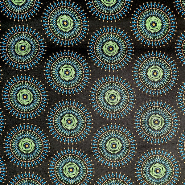 Original Shweshwe Stoff Disco Blue Sun mit grossen bunten Sonnenmotiven auf dunklem Hintergrund