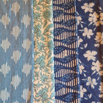Vier indische Baumwollstoffe mit floralen und grafischen Mustern in Blau und Weiss
