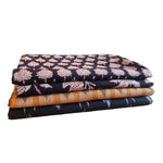 Detailansicht indischer Baumwollstoffe mit floralen Hand Block Print Mustern und gewebtem Ikat in Schwarz und Orange