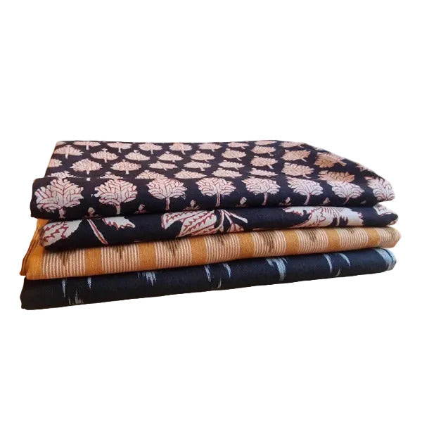 Detailansicht indischer Baumwollstoffe mit floralen Hand Block Print Mustern und gewebtem Ikat in Schwarz und Orange